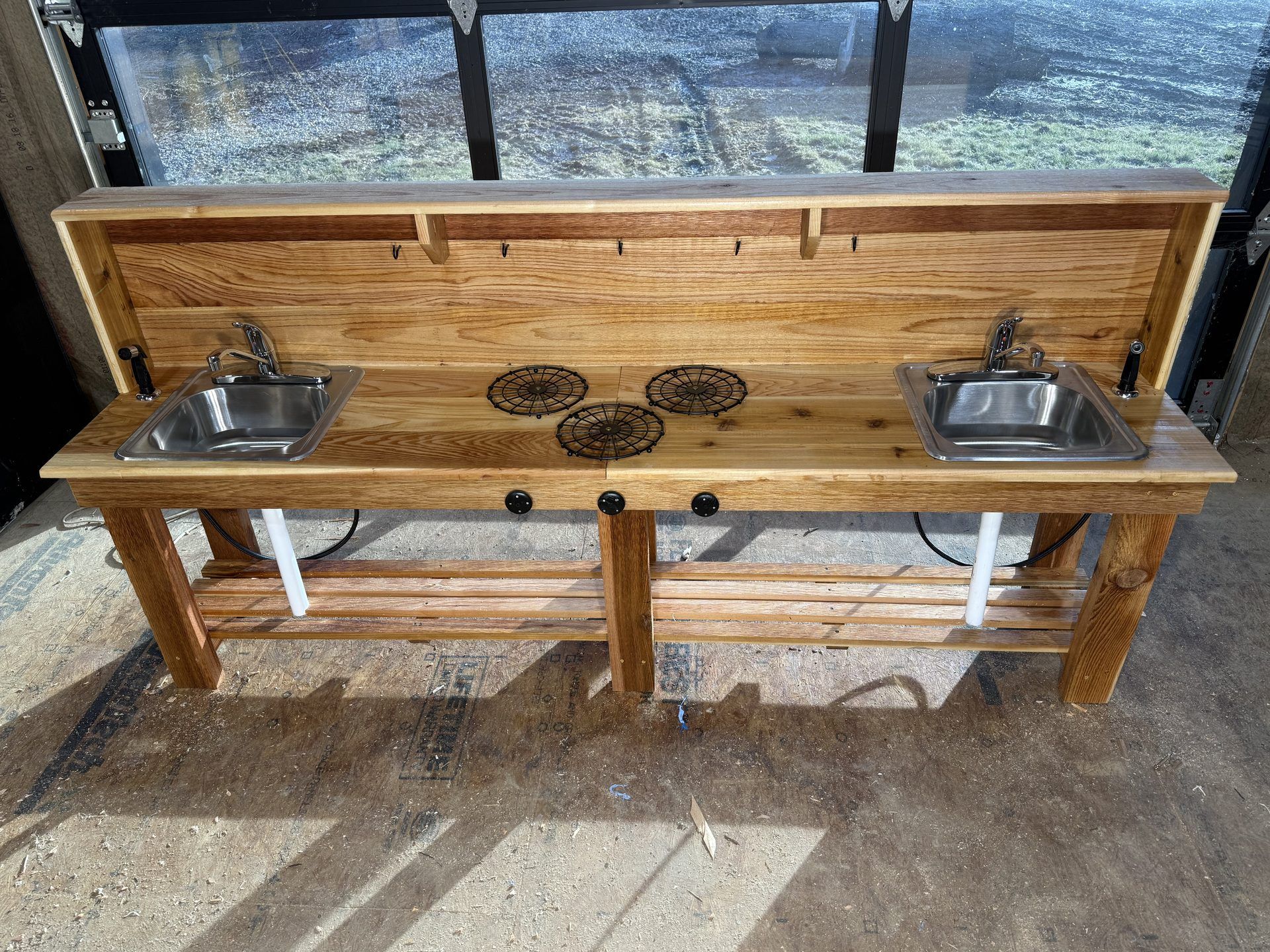Completed oak outdoor kitchen station with dual sinks and burners