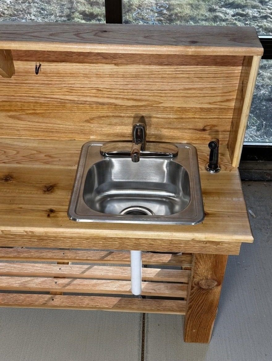 Close-up of oak outdoor kitchen station with stainless sink